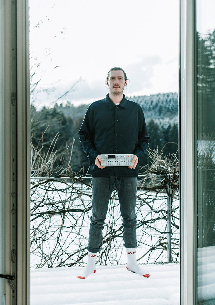 Produzent spielt auf einem OP1 Sampler draussen vor dem Haus