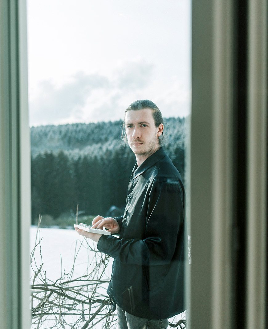 Produzent spielt auf einem OP1 Sampler draussen vor dem Haus