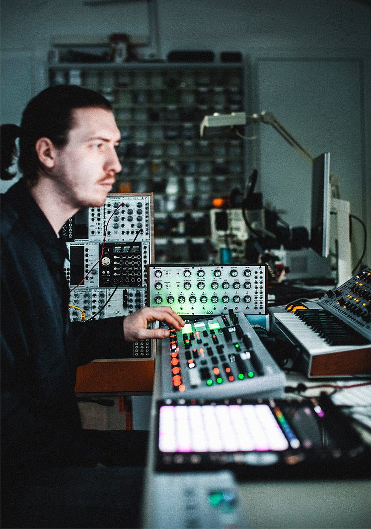 Musikproduzent in seinem Studio vor analogen Synthesizern