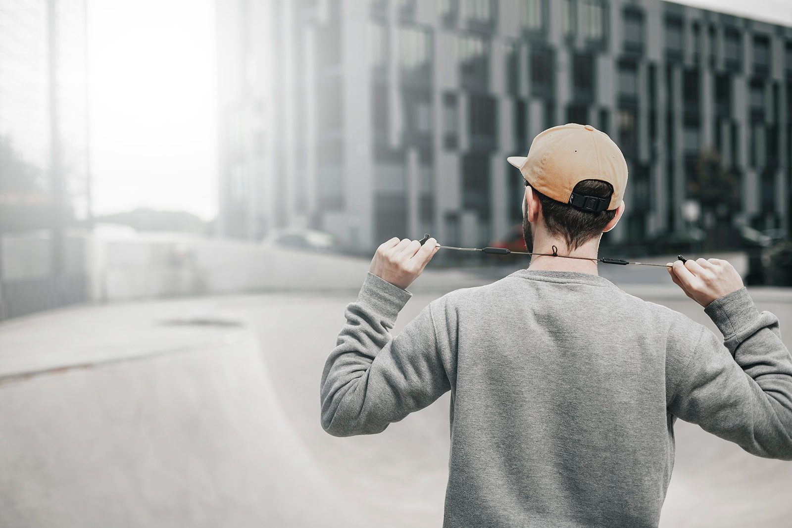 Skater nimmt sich die Kopfhörer raus, Pipe im Hintergrund
