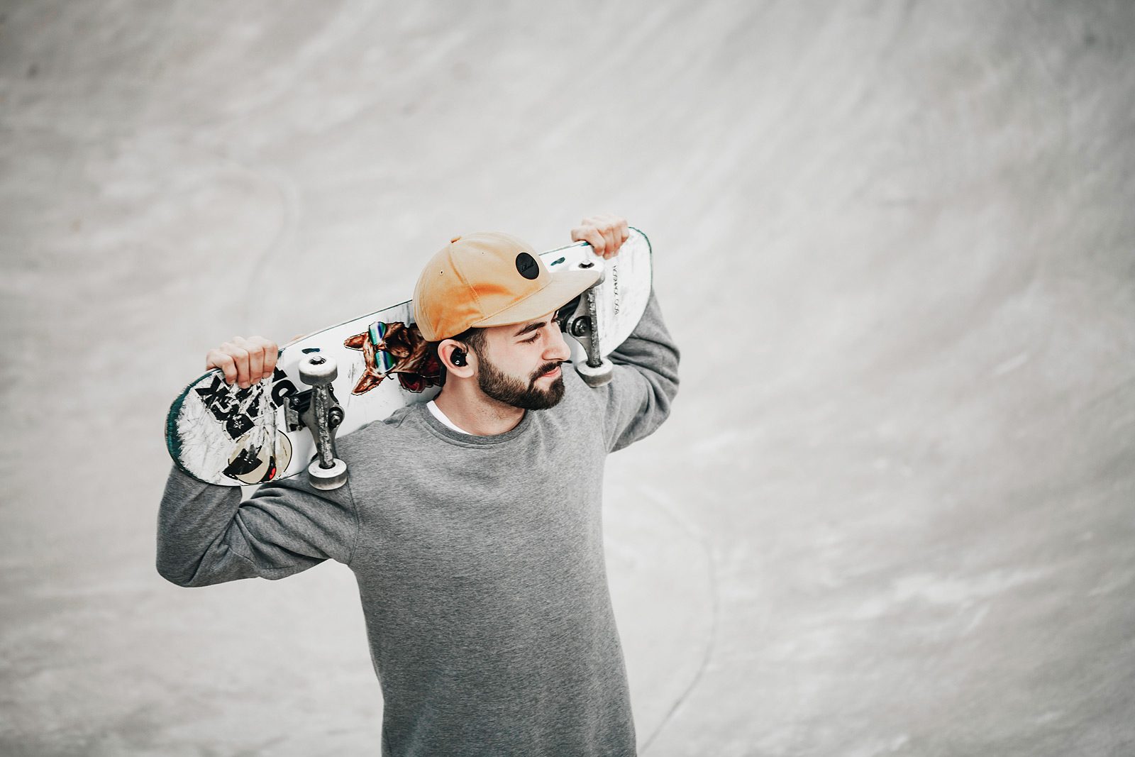 Skater mit Board auf den Schultern steht in der Pipe