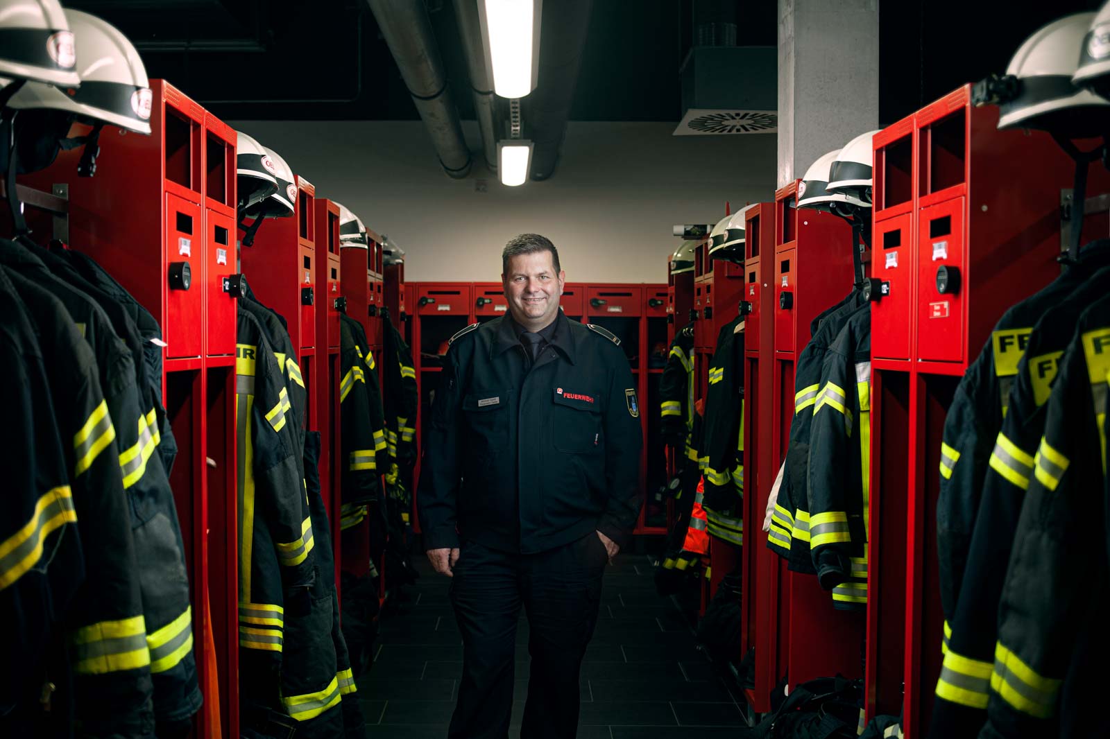 Leiter der Feuerwehr Minden in der Umkleide mit viel Ausrüstung