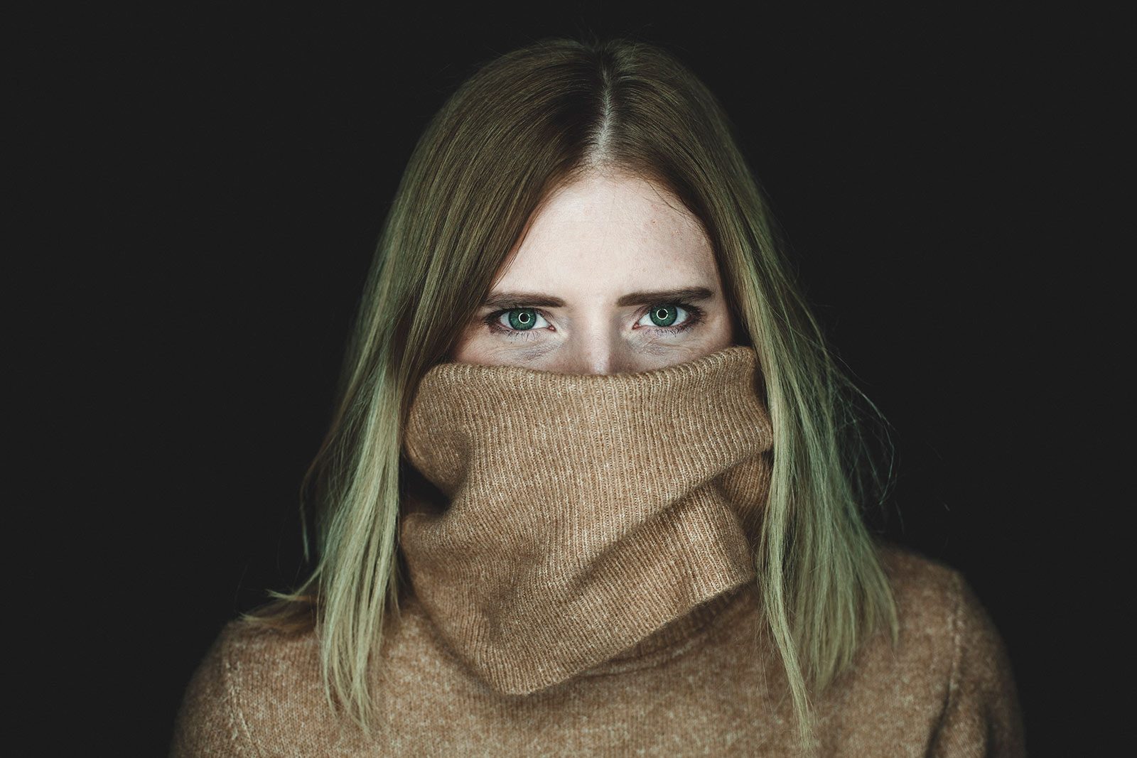 Portrait einer jungen Frau, Rollkragen bis über die Nase gezogen